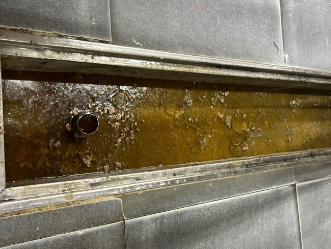 Hình ảnh dầu mỡ bị trào ngược tại đường ống thoát sàn của bếp nấu. Hình ảnh dầu mỡ bị trào ngược tại đường ống thoát sàn của bếp nấu.